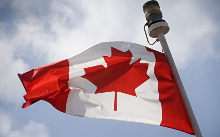 Canadian flag with red maple leaf waving, symbol of Canadian citizenship and immigration